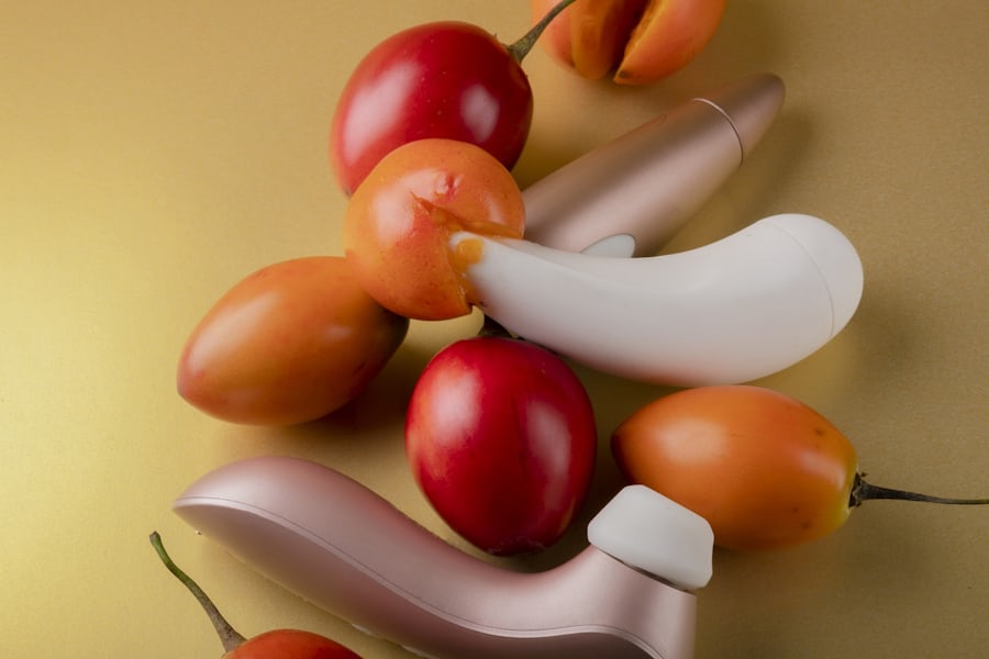 Succionador con vibración en tonos dorados junto a frutas exóticas, simbolizando placer intenso y estimulación sin fricción.