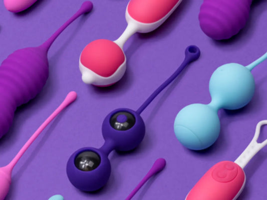 Varias bolas de amor de diferentes colores y diseños sobre fondo morado. Juguetes ideales para fortalecer el suelo pélvico y aumentar el placer femenino.