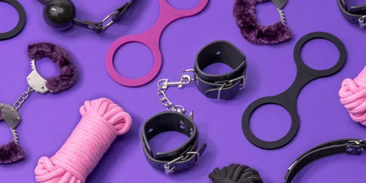 Esposas de peluche, grilletes de cuero, cuerdas y anillas de restricción sobre un fondo morado, accesorios ideales para juegos BDSM y bondage.